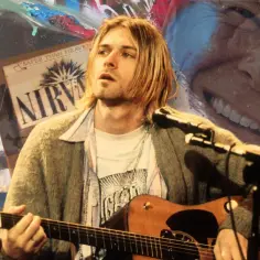 Kurt Cobain gra na gitarze, w tle logo Nirvana i cytat "We love u Kurt". Wizerunek nawiązuje do jego twórczości i wpływu.
