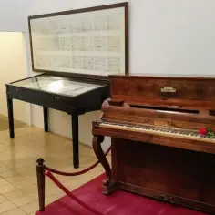 Muzyczne pamiątki po Chopinie na Majorce: fortepian, popiersie kompozytora i jego nuty.
