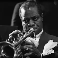 Louis Armstrong gra na trąbce, tworząc ponadczasowe utwory. Jego muzyka wciąż porusza serca słuchaczy.