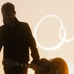 Michael Patrick Kelly z gitarą, w tle napis "The One". Inspiracja do jego utworów.