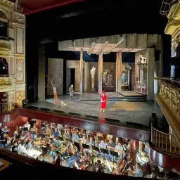 Orkiestra przygotowuje się do wykonania puccini opery. Na scenie trwa próba, a w loży widać fragmenty teatralnej scenografii.