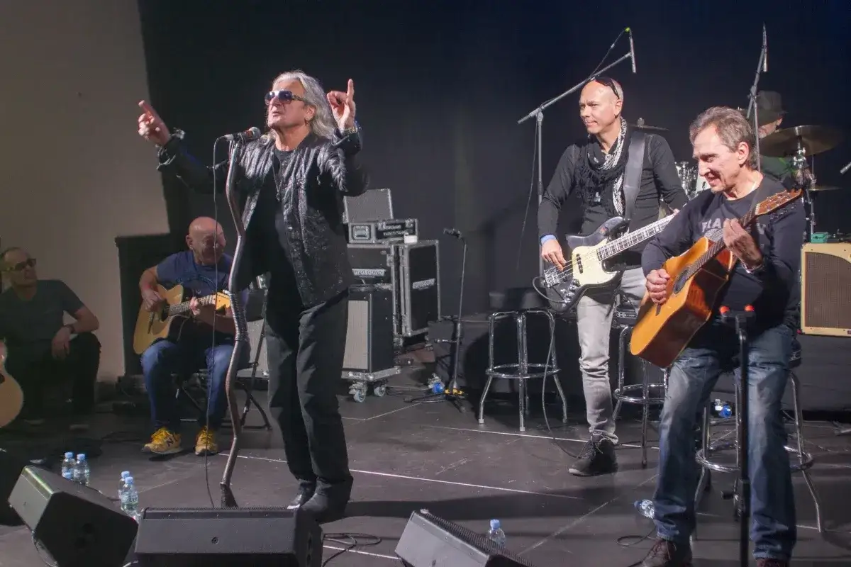 Zespół na scenie. Wokalista w skórzanej kurtce, gitarzysta basowy i akustyczny. Nie mogę ci wiele dać tekst, ale muzyka gra.