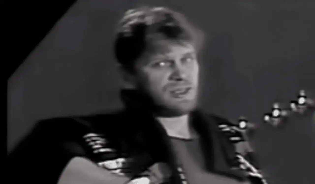 Mężczyzna gra na gitarze, śpiewając 