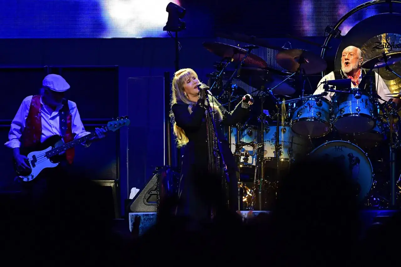 Stevie Nicks śpiewa, a Mick Fleetwood gra na perkusji. W tle basista, tworząc niezapomniane fleetwood mac utwory.