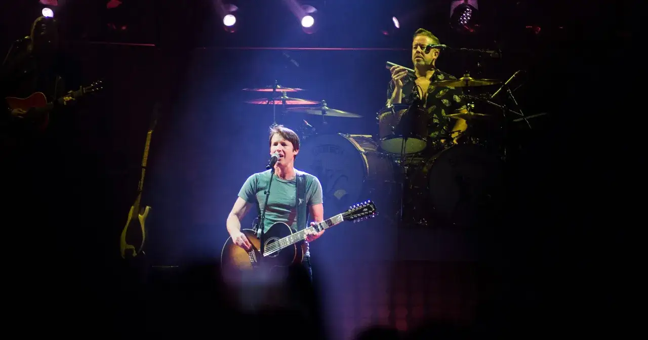 James Blunt śpiewa i gra na gitarze dwunastostrunowej. Na scenie widać też perkusistę.